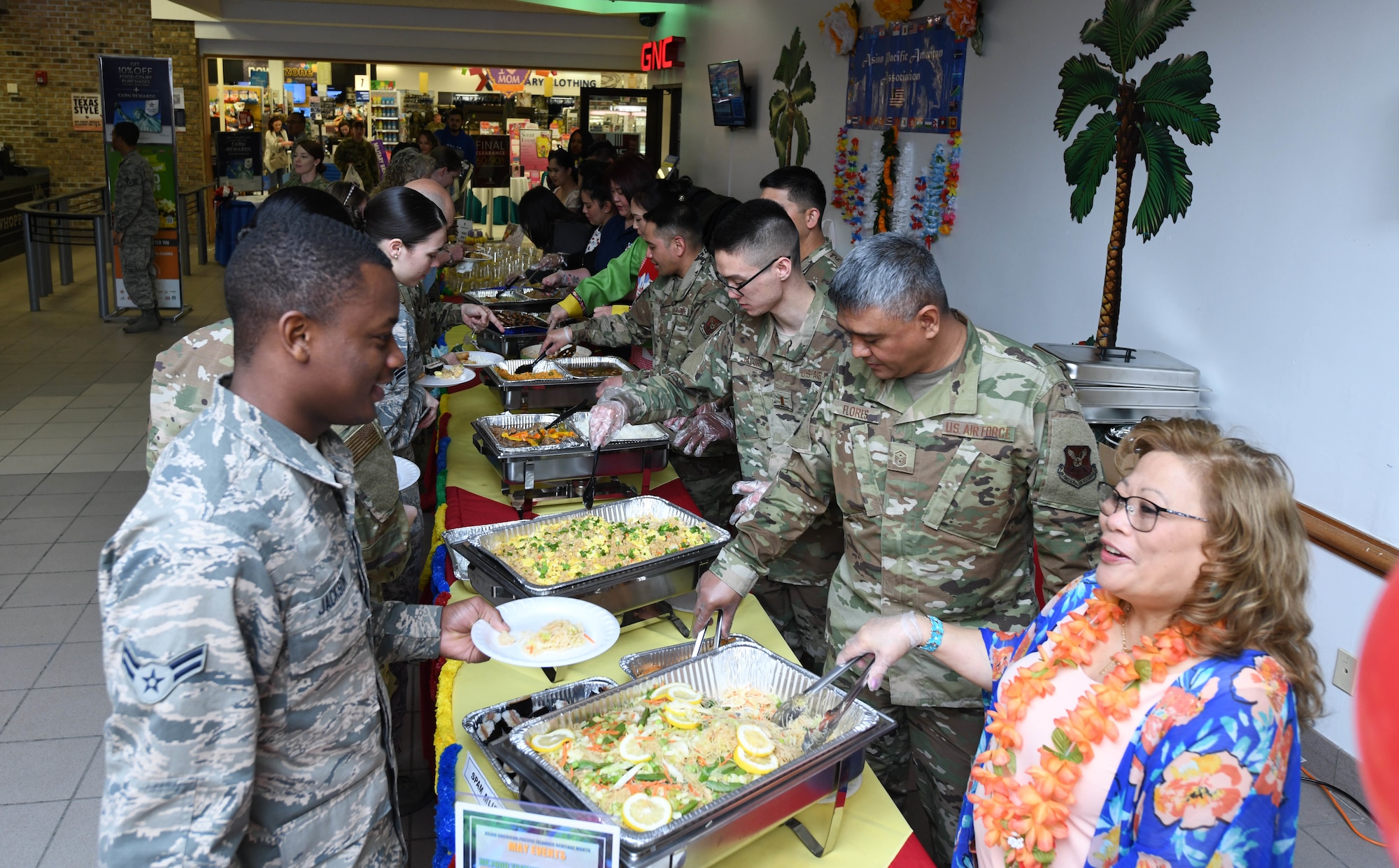 Airmen and their families line up to eat Asian and Pacific Islander influenced foods at Ellsworth Air Force Base, S.D., May 3, 2019. The Asian Pacific American Heritage Month celebration at The Exchange on base included unique foods, guest speakers and hula dancing. (U.S. Air Force photo by Senior Airman Thomas Karol)