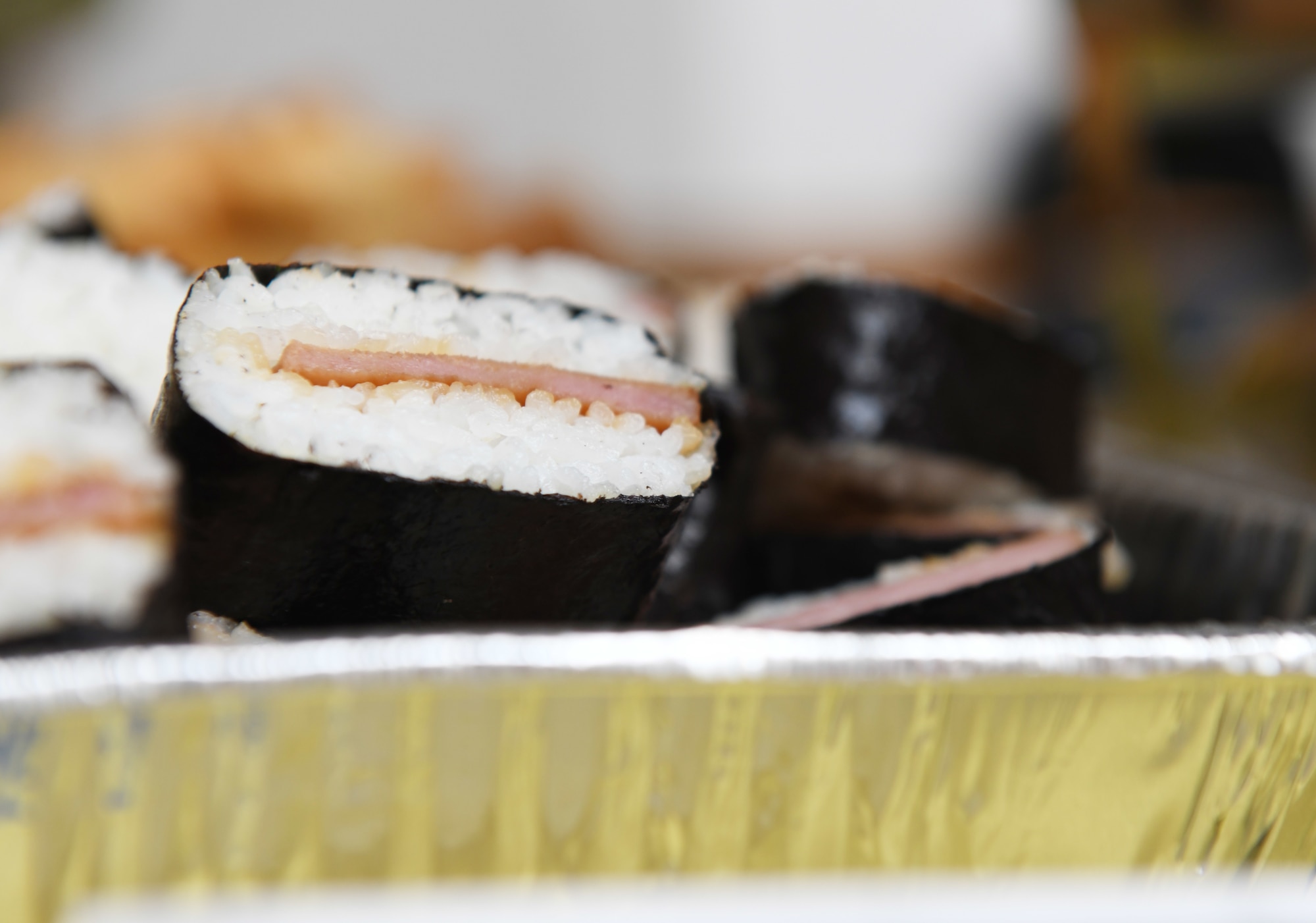 Spam musubi, a popular Hawaiian food, is prepared for consumption during a food tasting event at Ellsworth Air Force Base, S.D., May 3, 2019. Multiple different dishes were served at the Asian Pacific American Heritage Month celebration at The Exchange on base. (U.S. Air Force photo by Senior Airman Thomas Karol)