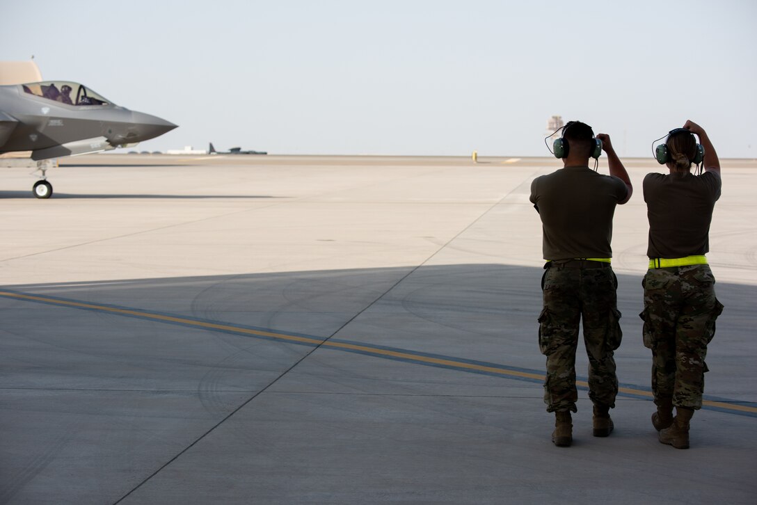 Two 380th Expeditionary Aircraft Maintenance Squadron F-35A Lightning II crew chiefs gesture to a 4th Expeditionary Fighter Squadron pilot April 26, 2019, at Al Dhafra Air Base, United Arab Emirates.