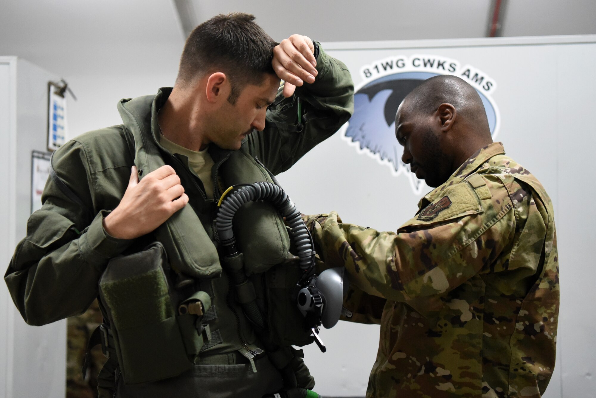 An F-35A Lightning II pilot assigned to the 4th Expeditionary Fighter Squadron receives assistance in securing gear to his sleeveless flight jacket in preparation for the first combat sortie in the U.S. Air Forces Central Command area of responsibility April 26, 2019, Al Dhafra Air Base, United Arab Emirates.