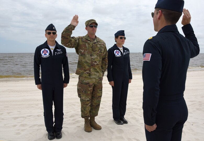 U.S. Air Force Maj. Ray Geoffroy, U.S. Air Force Thunderbirds public affairs officer #12, delivers the oath of reenlistment to Senior Airman Travis Beihl, 81st Training Wing Public Affairs specialist, prior to the Thunderbirds practice session for the Keesler and Biloxi Air Show in Biloxi, Mississippi, May 3, 2019. The Thunderbirds are headlining the unique joint air show with the city of Biloxi and Keesler AFB, May 4-5. The two-day event will also include various static displays on the flightline on base and aerial performances over the beach.(U.S. Air Force photo by Kemberly Groue)