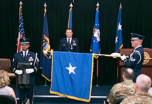 Brig. Gen. Rolf E. Mammen, commander of the 127th Wing and Selfridge Air National Guard Base, stands as the general officer flag is ceremoniously unfurled during his promotion ceremony here, May 4, 2019.