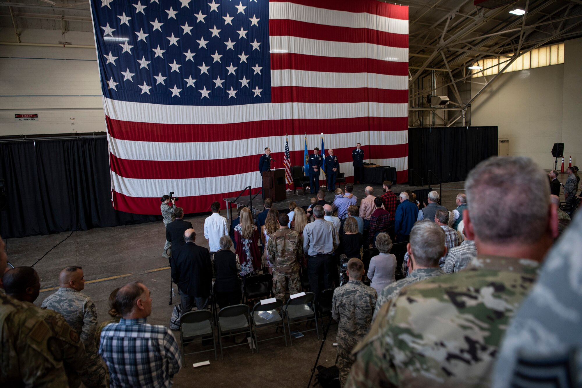 Col. Douglas Hayworth stands while the state song plays during his retirement ceremony at Will Rogers Air National Guard Base in Oklahoma City on May 4, 2019. Hayworth retired after serving more than 30 years with the Wing.(U.S. Air National Guard photo by Staff Sgt. Brigette Waltermire)