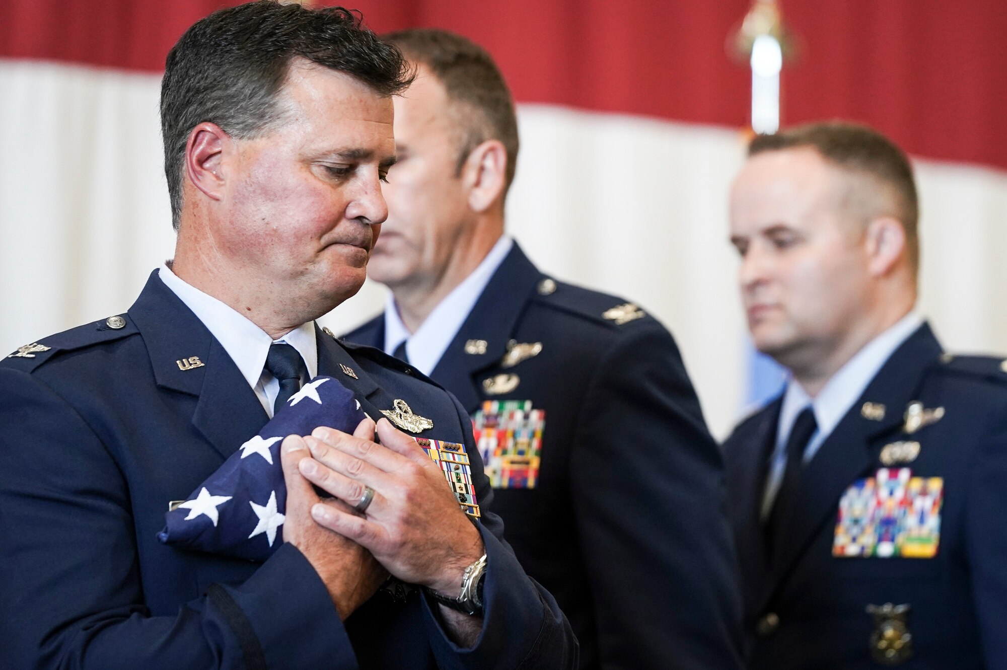 Col. Devin R. Wooden, former 137th Special Operations Wing commander, receives a flag from Airmen that represented each rank of his career during his retirement ceremony at Will Rogers Air National Guard Base, May 5, 2019. Wooden spent his entire career, nearly 33 years, promoting from Airman 1st Class to Colonel in the Oklahoma Air National Guard. (U.S. Air National Guard photo by Staff Sgt. Tyler Woodward)