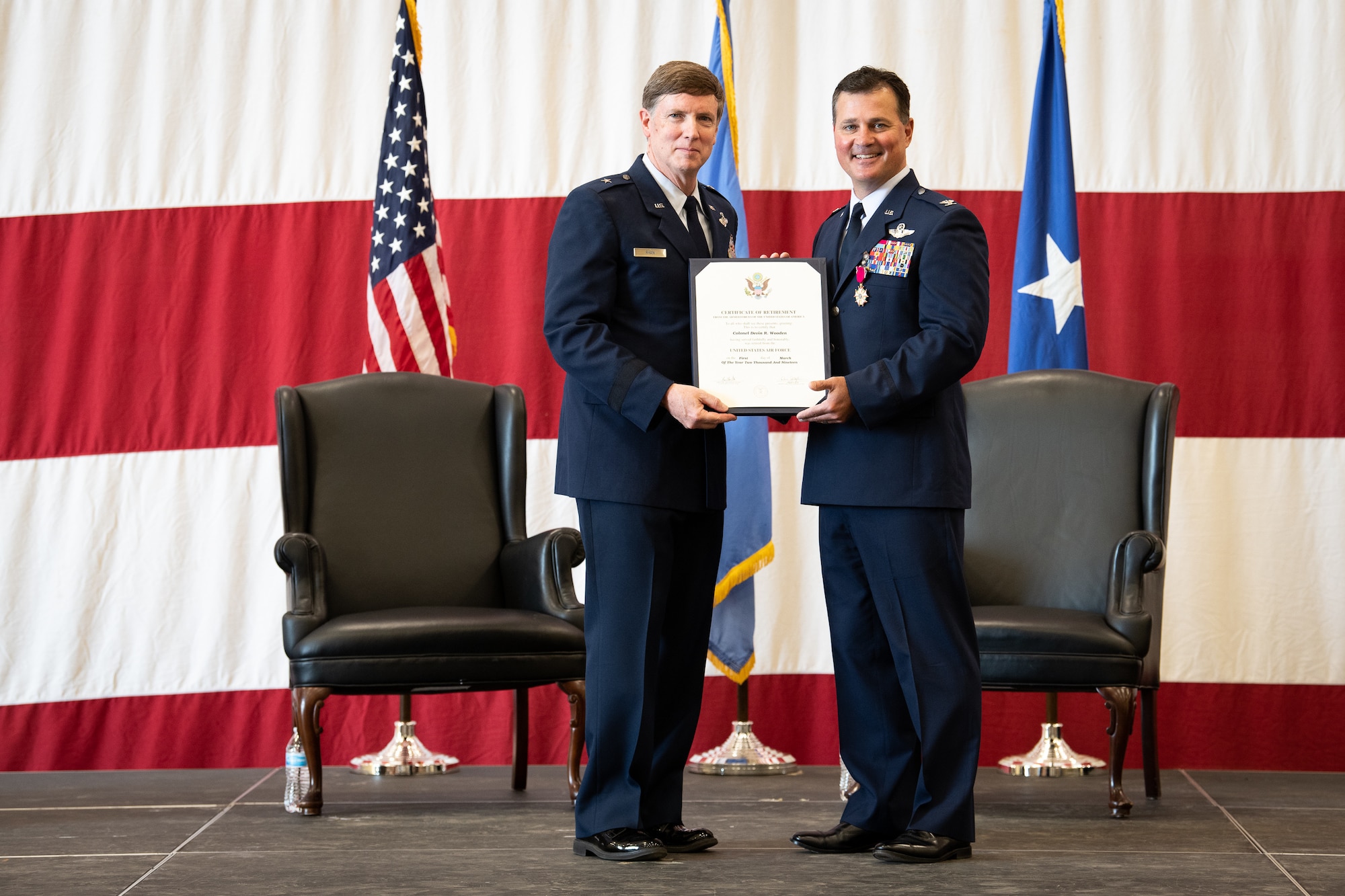 Col. Devin R. Wooden, former 137th Special Operations Wing commander, receives a certificate of retirement from the Oklahoma Assistant Adjutant General Brig. Gen. Thomas W. Ryan during his retirement ceremony at Will Rogers Air National Guard Base, May 5, 2019. Wooden spent his entire career, nearly 33 years, promoting from Airman 1st Class to Colonel in the Oklahoma Air National Guard. (U.S. Air National Guard photo by Senior Airman Jordan Martin)