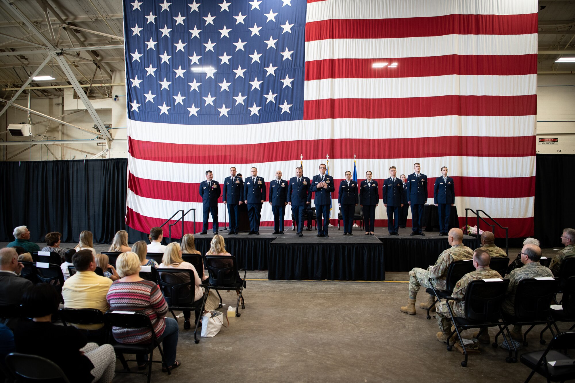 Col. Devin R. Wooden, former 137th Special Operations Wing commander, awaits a flag to be gifted to him featuring Airmen that represented each rank of his career during his retirement ceremony at Will Rogers Air National Guard Base, May 5, 2019. Wooden spent his entire career, nearly 33 years, promoting from Airman 1st Class to Colonel in the Oklahoma Air National Guard. (U.S. Air National Guard photo by Senior Airman Jordan Martin)