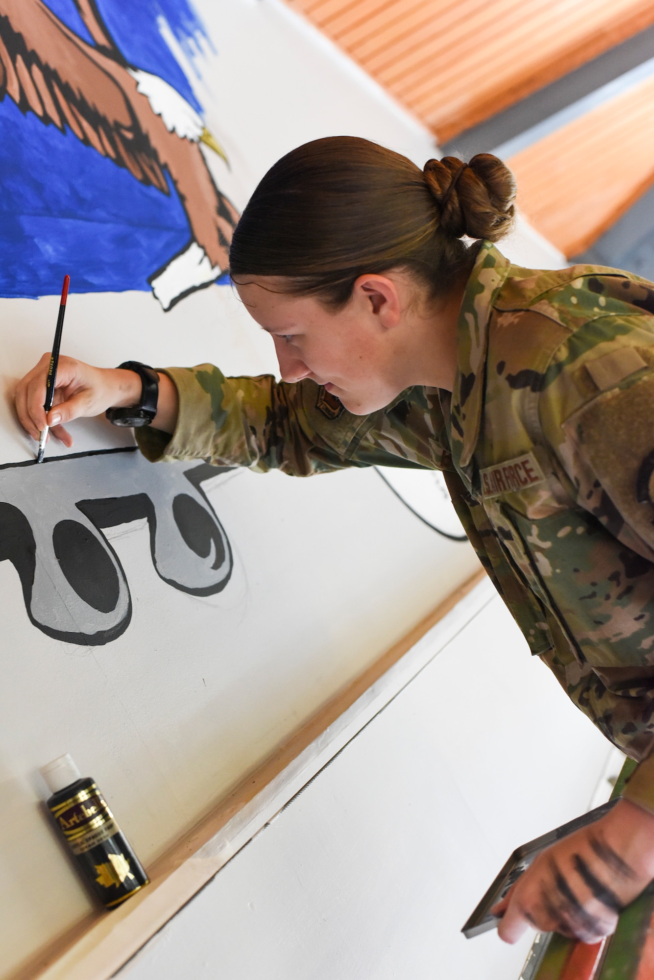 Airman First Class Amber Branch, 728th Air Mobility Squadron passenger services agent, paints a C-5 Galaxy on a mural in the squadron’s heritage room Feb. 1, 2019, at Incirlik Air Base, Turkey. Branch began drawing as a child and her love for it developed into creating paintings. (U.S. Air Force photo by Staff Sgt. Ceaira Tinsley)