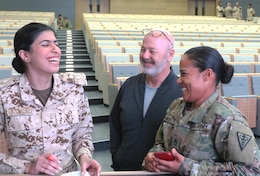 1st Lt. Maryam Abdulla, a doctor in the Bahrain Defence Force, and U.S. Army Sgt. 1st Class Misbah Bailey, 8th Medical Brigade, share a laugh while preparing a nine line at the Crown Prince Center of Training and Medical Research in Bahrain, April 16, 2019.