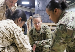 U.S. Army Maj. Tosha Nichols, 1st Theater Sustainment Command, watches as a tourniquet is applied during a medical subject matter expert exchange at the Crown Prince Center of Training and Medical Research in Bahrain, April 15, 2019.