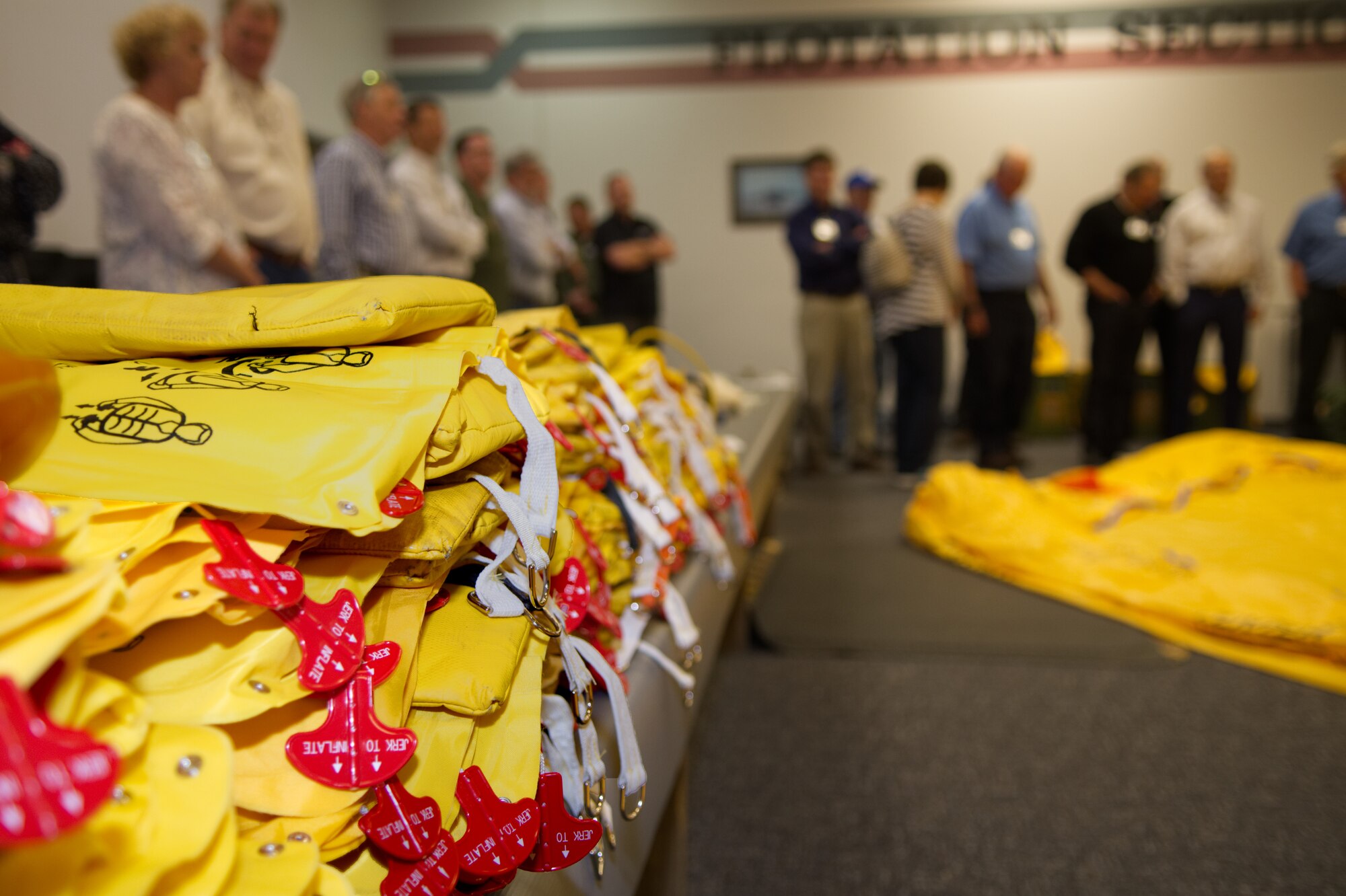 Life vests lay in stacks as civic leaders from Dyess Air Force Base listen to a presentation about aircrew flight equipment at the 445th Airlift Wing, May 1, 2019 at Wright-Patterson AFB, Ohio.  They learned more about the important role aircrew flight equipment plays in completing sorties and saving lives. The group visited multiple areas within the 445th AW to learn more about Air Force operations. (U.S. Air Force photo by Master Sgt. Ted Daigle)