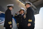 The official party from the Arleigh Burke-class guided-missile destroyer USS Donald Cook (DDG 75) salute as the color guard parades the colors during a change of command ceremony for the ship, May 3, 2019.