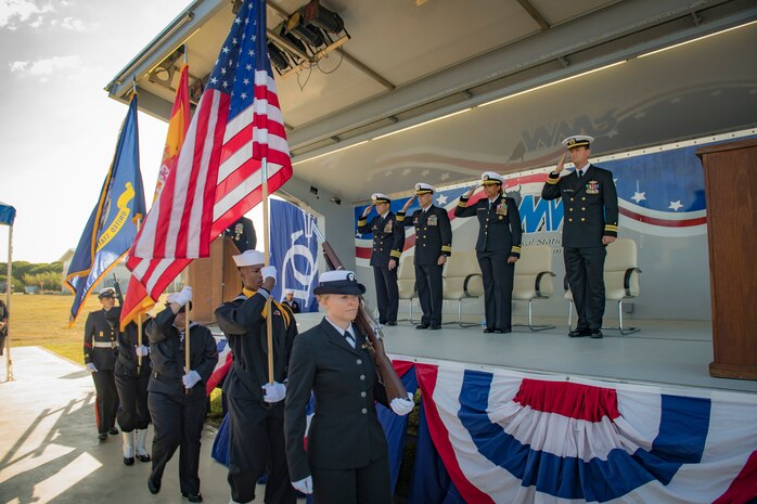 The official party from the Arleigh Burke-class guided-missile destroyer USS Donald Cook (DDG 75) salute as the color guard parades the colors during a change of command ceremony for the ship, May 3, 2019.
