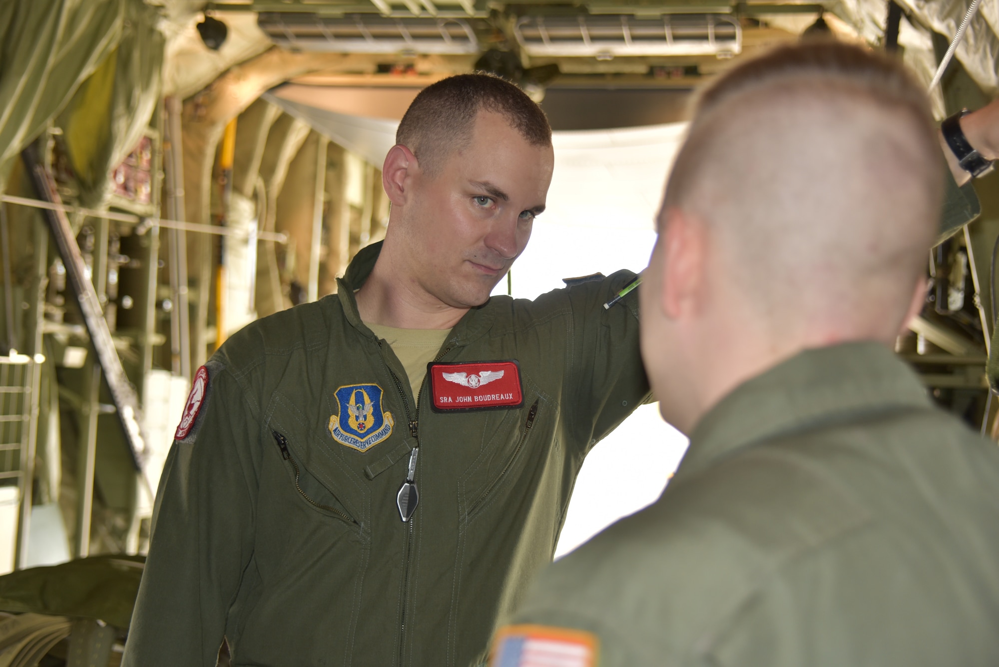 Senior Airman John Boudreaux (left) and Tech. Sgt. Joe Helm (right), 815th Airlift Squadron loadmasters, discuss the training mission while on board a C-130J Super Hercules, April 18, 2019, Keesler Air Force Base, Mississippi. Boudreaux suffered three fractured vertebra in a car wreck. After receiving surgery and completing physical therapy, he attended loadmaster school for a second time and is in the process of completing his training to become a fully qualified loadmaster.  (U.S. Air Force photo by Tech Sgt. Michael Farrar)