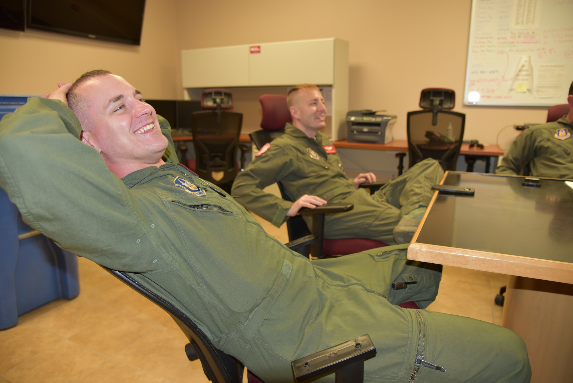 Senior Airman John Boudreaux (left) and Tech Sgt. Joe Helm (right), 815th Airlift Squadron loadmasters, relax after their training mission was completed during a post flight briefing, April 18, 2019, Keesler Air Force Base, Mississippi. Boudreaux suffered three fractured vertebra in a car wreck. After receiving surgery and completing physical therapy, he attended loadmaster school for a second time and is in the process of completing his training to become a fully qualified loadmaster.  (U.S. Air Force photo by Tech Sgt. Michael Farrar)