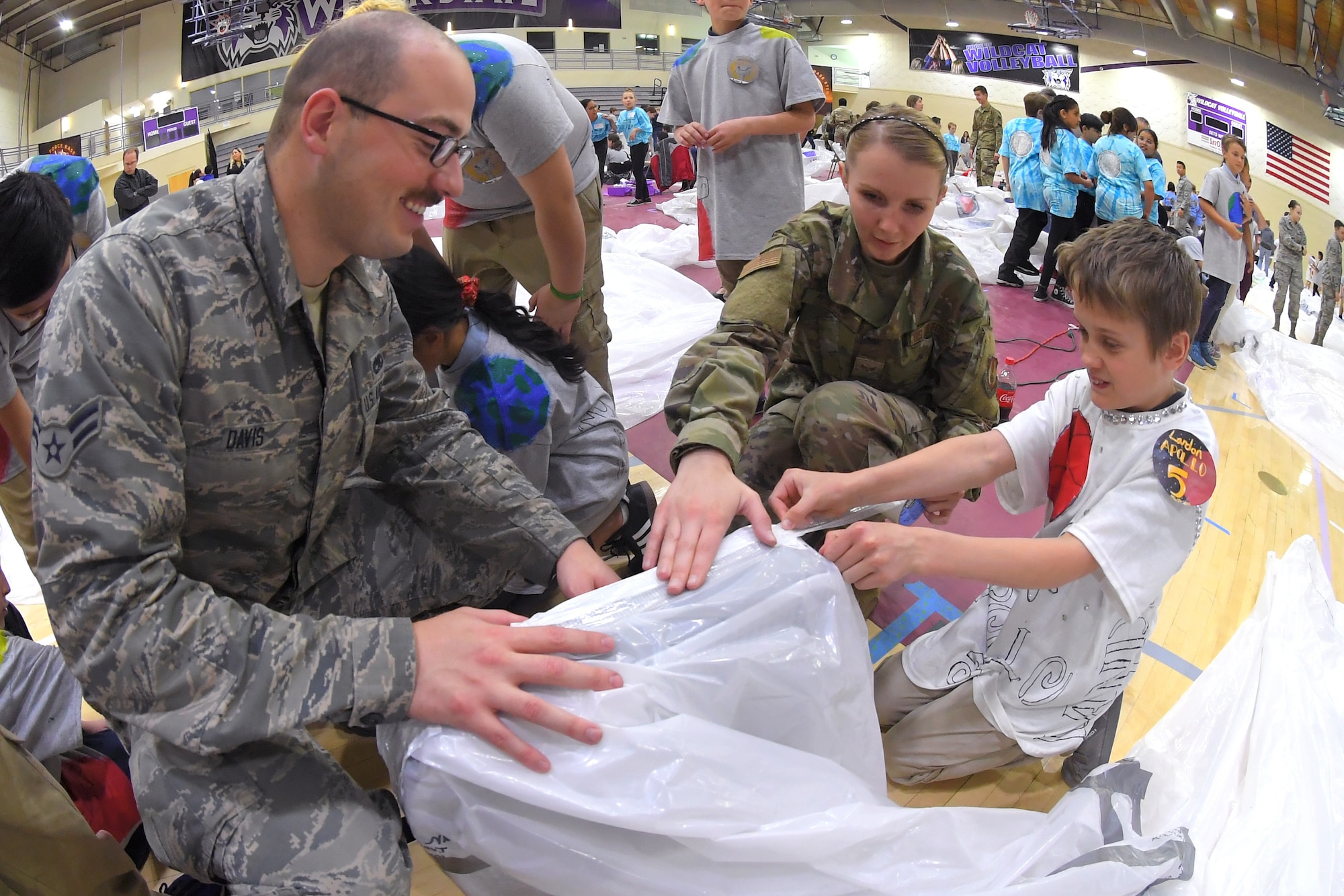 (Left to right) Airman 1st Class Zack Davis and Senior Airman Ashley Carey, both 649th Munitions Squadron, assist a fifth grade student with building a simulated space habitat during ‘Mission to Mars’ at Weber State University May 2, 2019. Mission to Mars is facilitated by Hill Air Force Base as part of the STEM Outreach Program, which partners with local school teachers by providing a curriculum, materials and events to teach STEM-related subjects in a creative and fun environment. (U.S. Air Force photo by Todd Cromar)