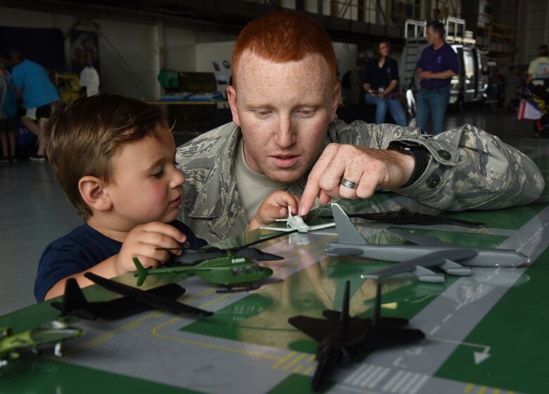 U.S. Air Force Staff Sgt. Stephen Hughes, 334th Training Squadron instructor, uses toy air planes to provide an air traffic control demonstration to Maverick Vanhuss of Metairie, Louisiana, inside the Science, Technology, Engineering and Mathematics demonstrations hangar on the flightline during the Keesler and Biloxi Air and Space Show at Keesler Air Force Base, Mississippi, May 4, 2019. The two-day event included various static displays on the flightline on base and the U.S. Air Force Thunderbirds, U.S. Army Black Daggers and other aerial performances over the beach. Thunder Over the Sound is a unique, one-of-a-kind event where a base and its surrounding city have jointly hosted one air show taking place in two locations. (U.S. Air Force photo by Kemberly Groue)