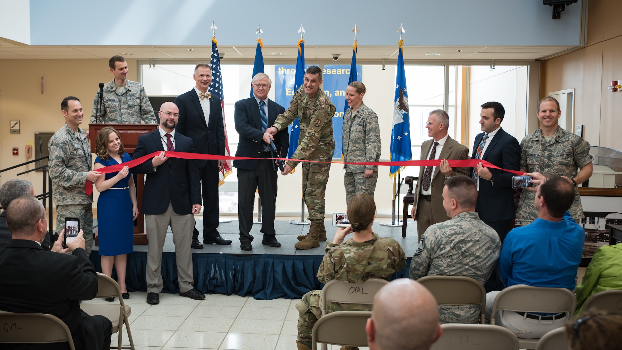 Jack Blackhurst, executive director of the Air Force Research Laboratory, and Brig. Gen. Mark Koeniger, commander of the 711th Human Performance Wing, prepare to cut a ceremonial red ribbon in honor of the activation of the Warfighter Medical Optimization Division, one of five divisions comprising the 711HPW’s Airman Systems Directorate. The activation ceremony was held May 1 at the United States Air Force School of Aerospace Medicine. (U.S. Air Force photo/Rick Eldridge)