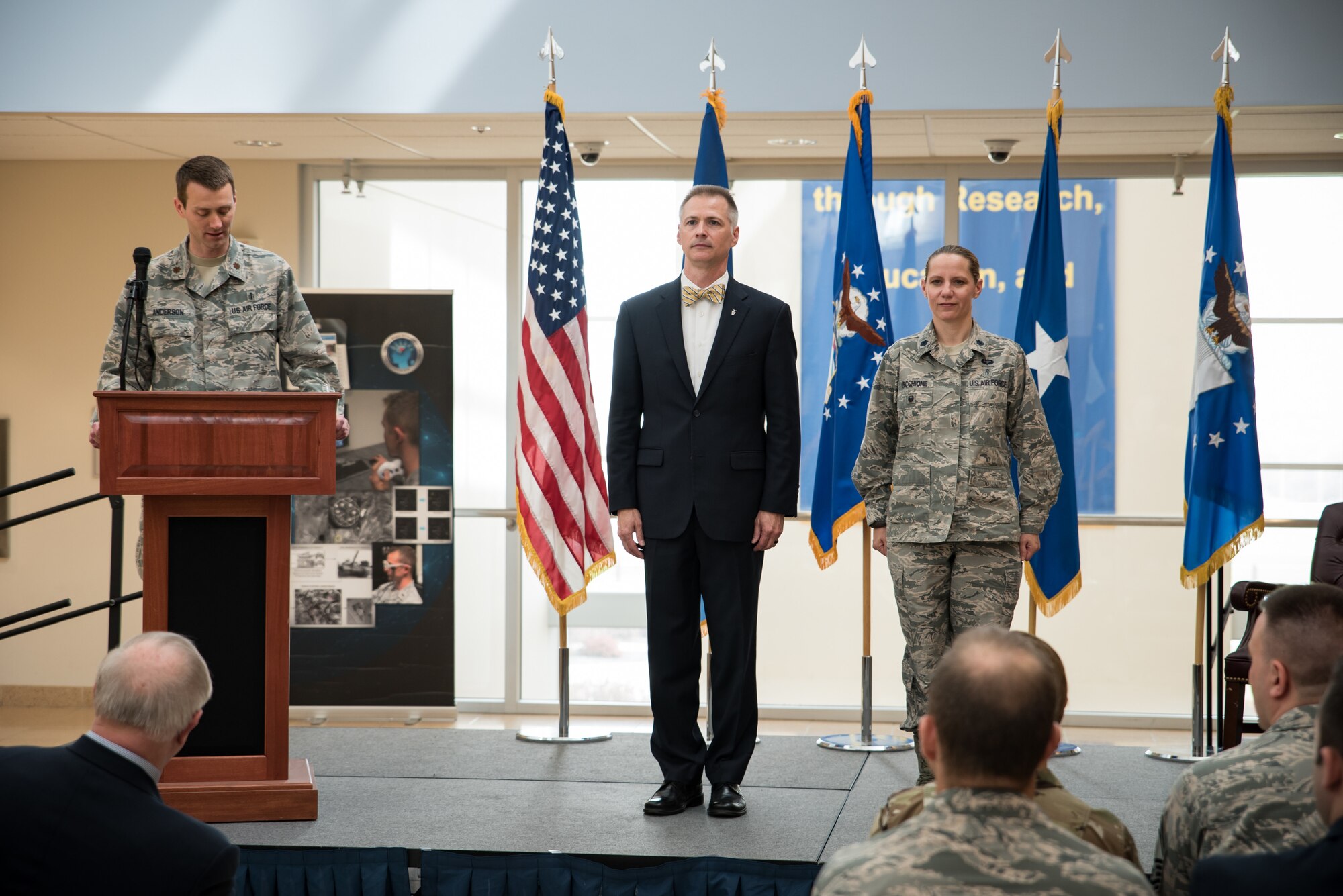 Dr. Kevin Geiss, director of the 711th Human Performance Wing's Airman Systems Directorate, and Lt. Col. Jennifer Vecchione, chief of the newly established Warfighter Medical Optimization Division stand during the reading of the charter activation document at a ceremonial ribbon cutting ceremony in honor of the activation of the Warfighter Medical Optimization Division, one of five divisions comprising the Airman Syustems Directorate. The activation ceremony was held May 1 at the United States Air Force School of Aerospace Medicine. (U.S. Air Force photo/Rick Eldridge)