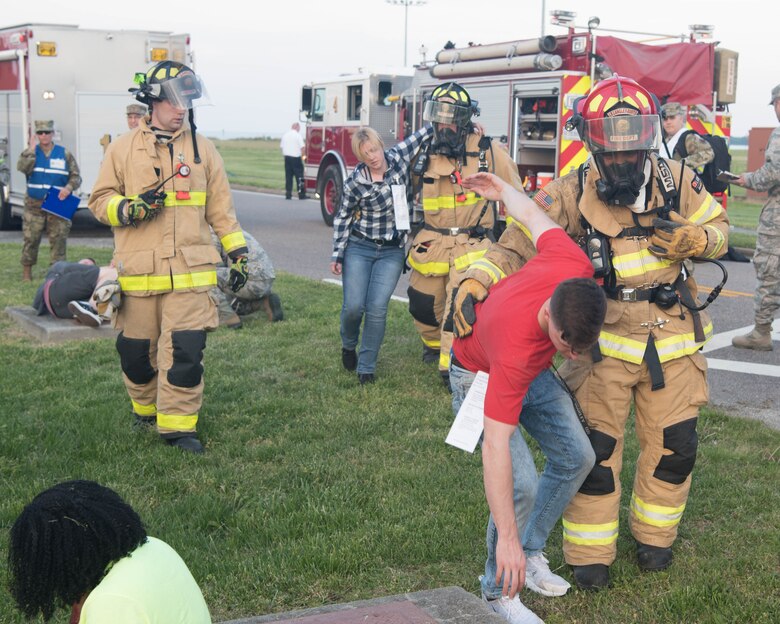 Firefighters on base help guide simulated victims to a makeshift triage center during an exercise on Joint Base Langley-Eustis, Virginia, April 25, 2019. The firefighters had to guide over ten simulated victims to the makeshift triage center where they could receive first aid.(U.S. Air Force photo by Airman 1st Class Marcus M. Bullock)