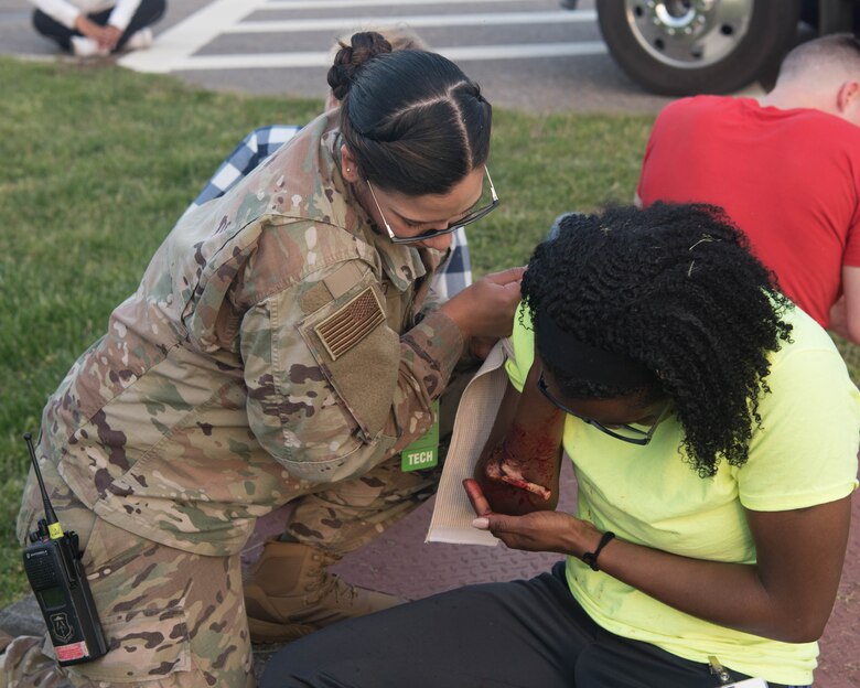 U.S. Air Force Staff Sgt. Amanda Rosado, 633d Aerospace Medicine Squadron flight operational medical technician, helps bandage a simulated victim during an exercise on Joint Base Langley- Eustis, Virginia, April 25, 2019. Rosado and other members of the 633d AMS were part of the Field Response Team during the exercise tasked with being the first to respond to mass base emergencies and flight line base emergencies. (U.S. Air Force photo by Airman 1st Class Marcus M. Bullock)