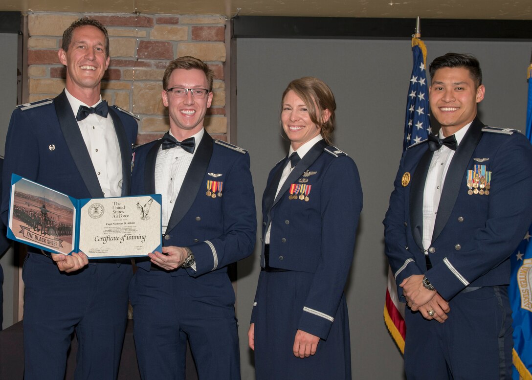 Lt. Col. Mark Sletten, 8th Fighter Squadron commander, presents Capt. Nicholas Atkins, 8th FS F-16 Basic Course graduate, with a certificate of training, May 4, 2019, at Club Holloman on Holloman Air Force Base, N.M. Eight Viper pilot students graduated from the 8th FS first F-16 B-Course, nearly eighty years since the squadron's induction on Nov. 20, 1940. (U.S. Air Force photo by Airman 1st Class Kindra Stewart)