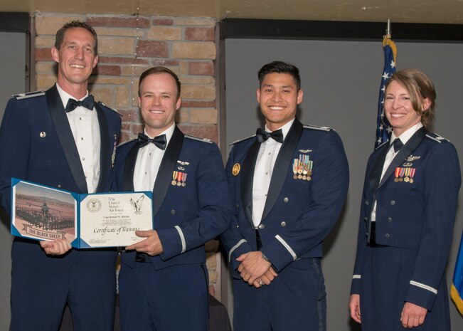 Lt. Col. Mark Sletten, 8th Fighter Squadron commander, presents Capt. Robert Ritchie, 8th FS F-16 Basic Course graduate, with a certificate of training, May 4, 2019, at Club Holloman on Holloman Air Force Base, N.M. Eight Viper pilot students graduated from the 8th FS first F-16 B-Course, nearly eighty years since the squadron's induction on Nov. 20, 1940. (U.S. Air Force photo by Airman 1st Class Kindra Stewart)