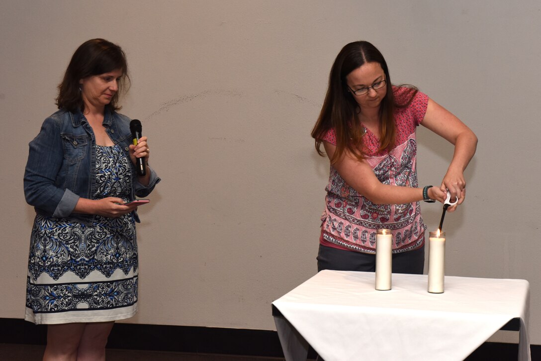 President of the Congregation of Beth Israel Amy Flint, says a prayer while, member of the Congregation of Beth Israel, Amanda Bradley  lights two candles in honor of the memory of those who were murdered during the Holocaust at the Event Center on Goodfellow Air Force Base, Texas, May 1, 2019. The candles also served as a reminder of those who spoke out and saved or tried to save Jews and the allied troops who liberated camps. (U.S. Air Force photo by Senior Airman Seraiah Hines/Released)