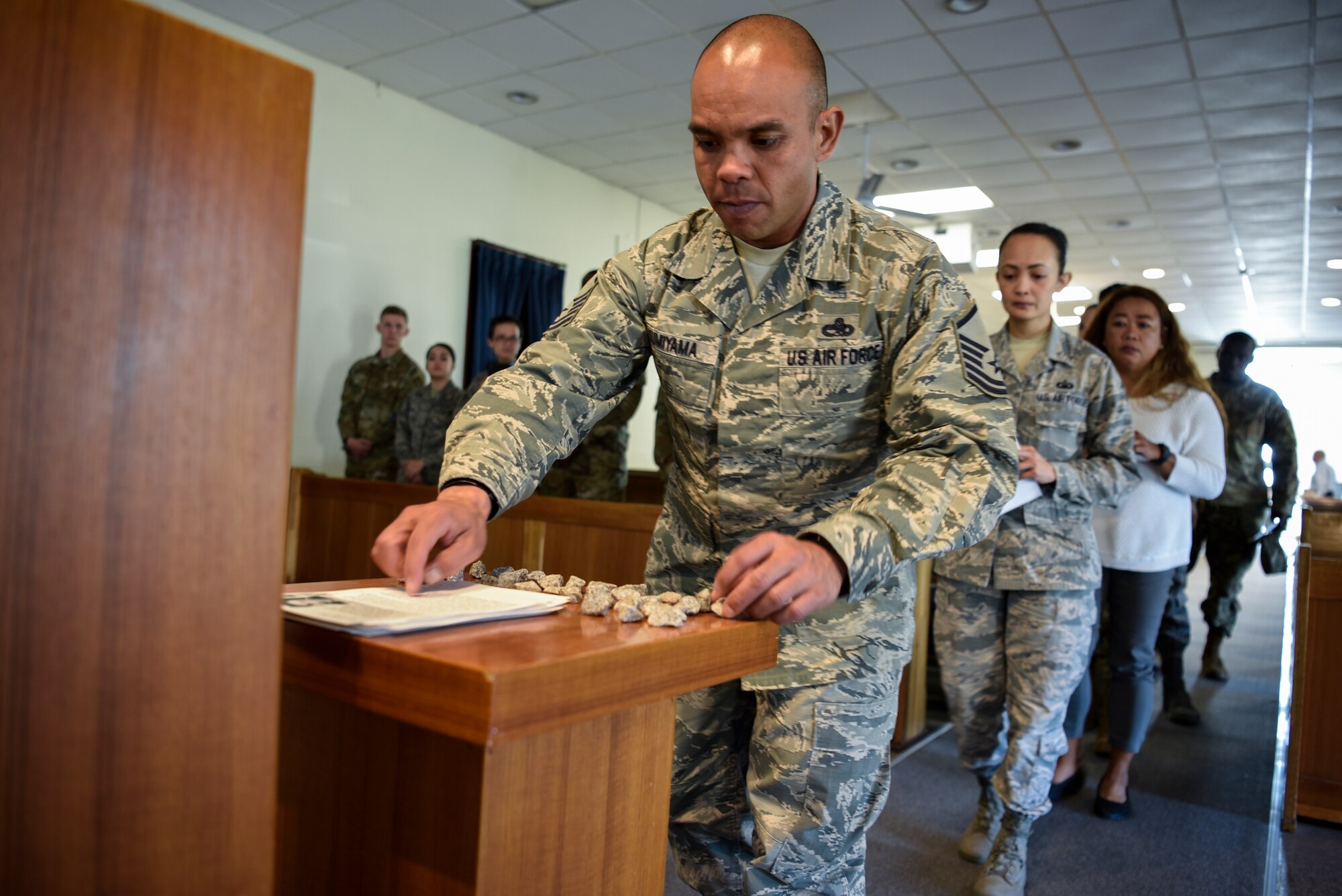 Master Sgt. Michael Kumiyama, 8th Force Support Squadron career assistant advisor, places a story of the Holocaust victims and a pebble on a table during Kunsan Air Base’s Holocaust Remembrance Ceremony at the Base Chapel on May 2, 2019. The ceremony is part of the national Days of Remembrance observance established by Congress to commemorate the Holocaust. This year, it is observed from April 28 through May 5. (U.S. Air Force photo by Capt. Remoshay Nelson)