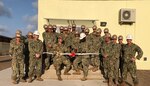 Seabees assigned to Naval Construction Battalion (NMCB) 133 pose for a photo with U.S. Army Maj. WooWon Chung, office of security cooperation at U.S. Embassy Libreville, during a ribbon cutting ceremony for Gabon's newly-constructed maritime operations center, May 3, 2019.