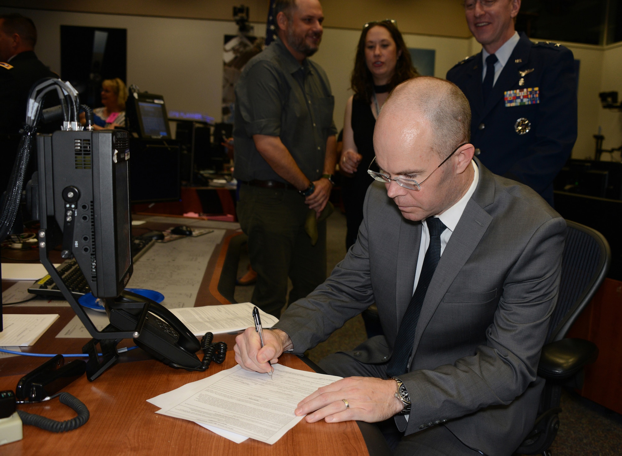 Dr. Benjamin Johansen, signs his name, becoming a captain in the Air Force Reserve assigned to the 433rd Airlift Wing, Joint Base San Antonio-Lackland, Texas, as a flight surgeon. He was administered the commissioning oath by Army Lt. Col. Anne McClain, an astronaut on the International Space Station, 210 miles above earth. (Air Force photo/Master Sgt. Chance Babin)