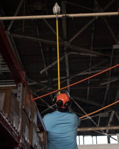 JD Bales, mechanical engineer with the Propulsion, Structures & Manufacturing Enterprise Branch of the Materials and Manufacturing Directorate, lifts a new light bulb into place at Joint Base Langley-Eustis, Virginia, April 30, 2019. The lightbulbs being used are part of the 633d Air Base Wing Arrow Spark program. The light bulbs have not been replaced in more than 10 years. (U.S. Air Force photo by Airman 1st Class Marcus M. Bullock)