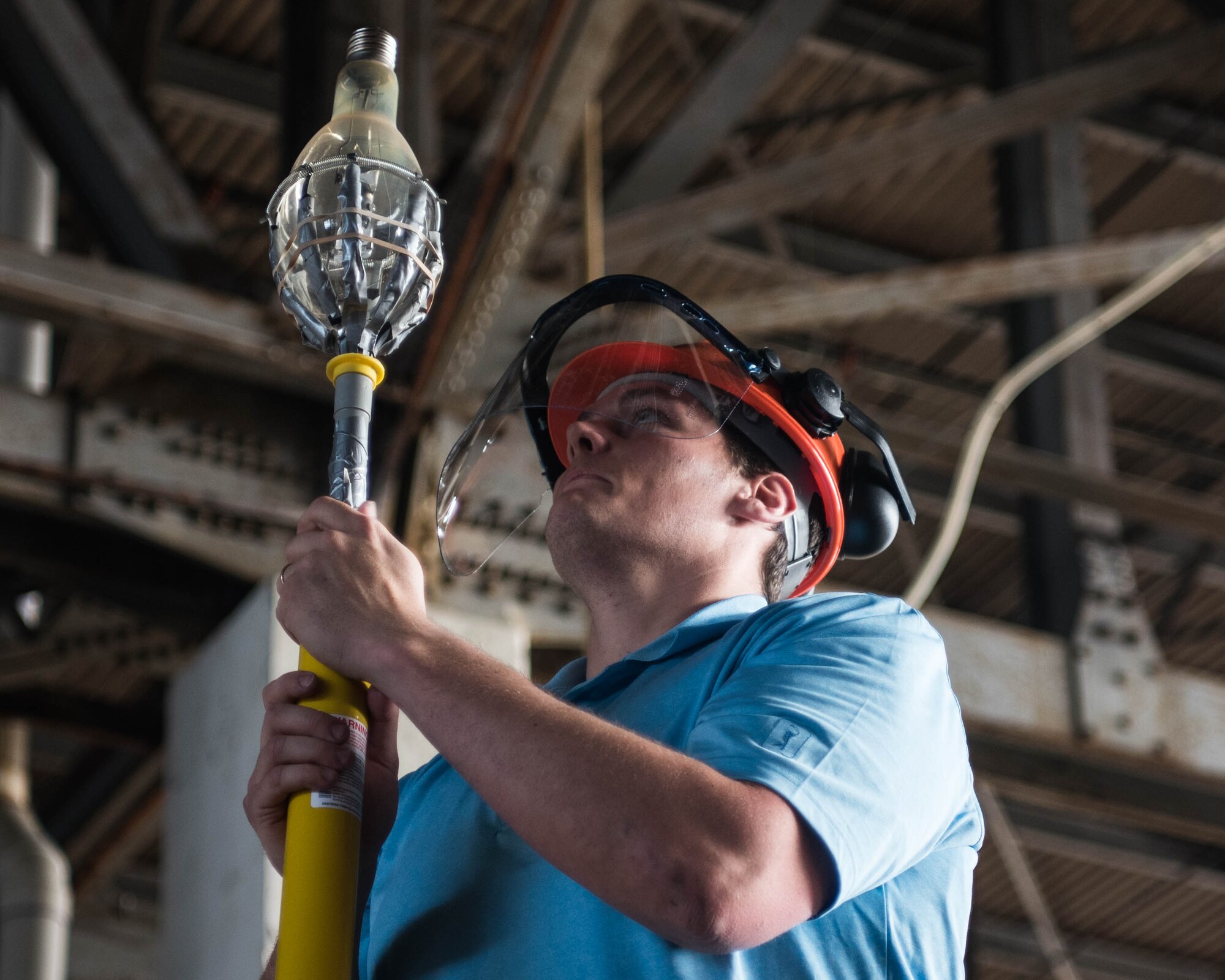 JD Bales, mechanical engineer with Propulsion, Structures & Manufacturing Enterprise Branch of the Materials and Manufacturing Directorate, inspects an old light bulb that he removed at Joint Base Langley-Eustis, April 30, 2019.The unit did not have the necessary equipment to change the old lightbulbs until an idea was submitted through the 633d Air Base Wing Arrow Spark program. (U.S. Air Force photo by Airman 1st Class Marcus M. Bullock)