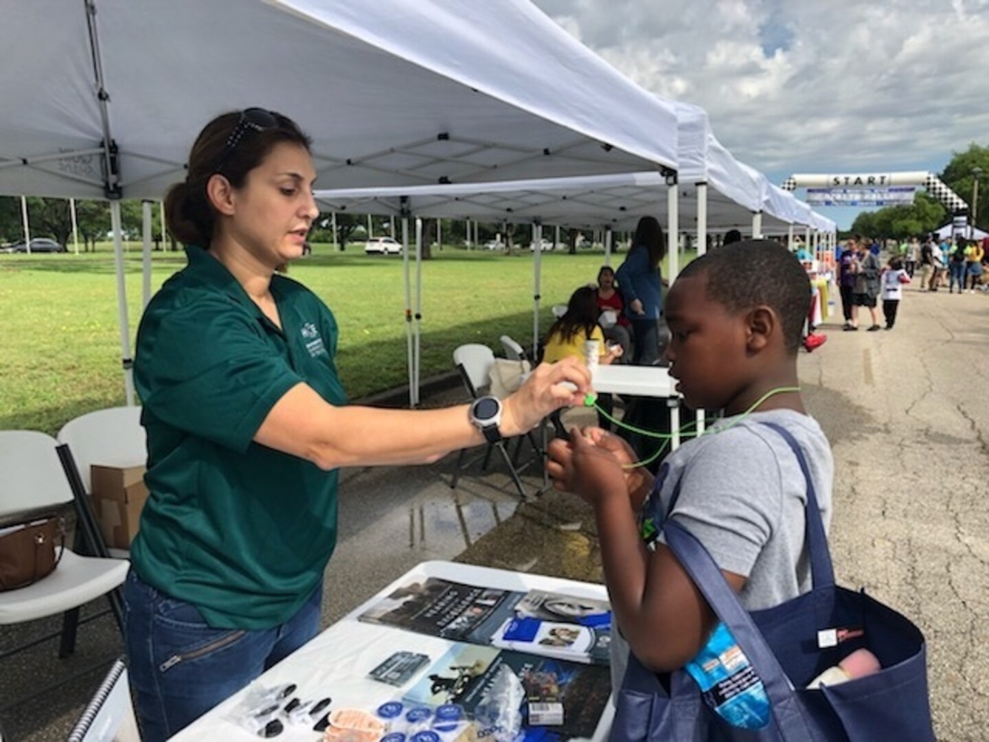 Maj. Malisha Martukovich, the Air Force liaison for the Department of Defense’s Hearing Center of Excellence, discusses hearing conservation with a participant, and demonstrates how to properly wear earplugs at the 59th Medical Wing Health Rally and Fun Run May 4 at Joint Base San Antonio Randolph Air Force Base. The event featured more than 20 vendors promoting health and wellness services and resources for active duty and family members.