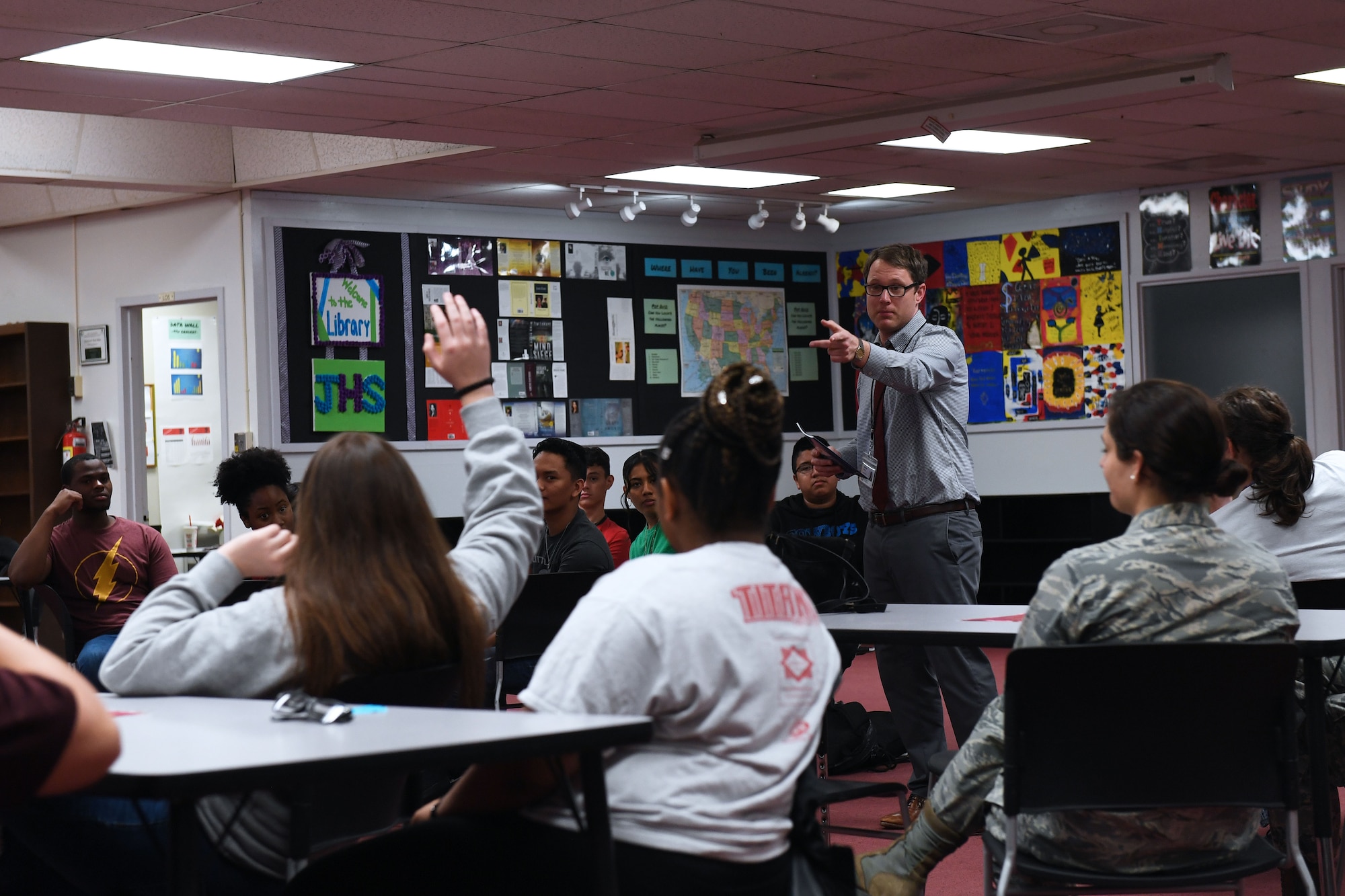 A student raises their hand in the classroom