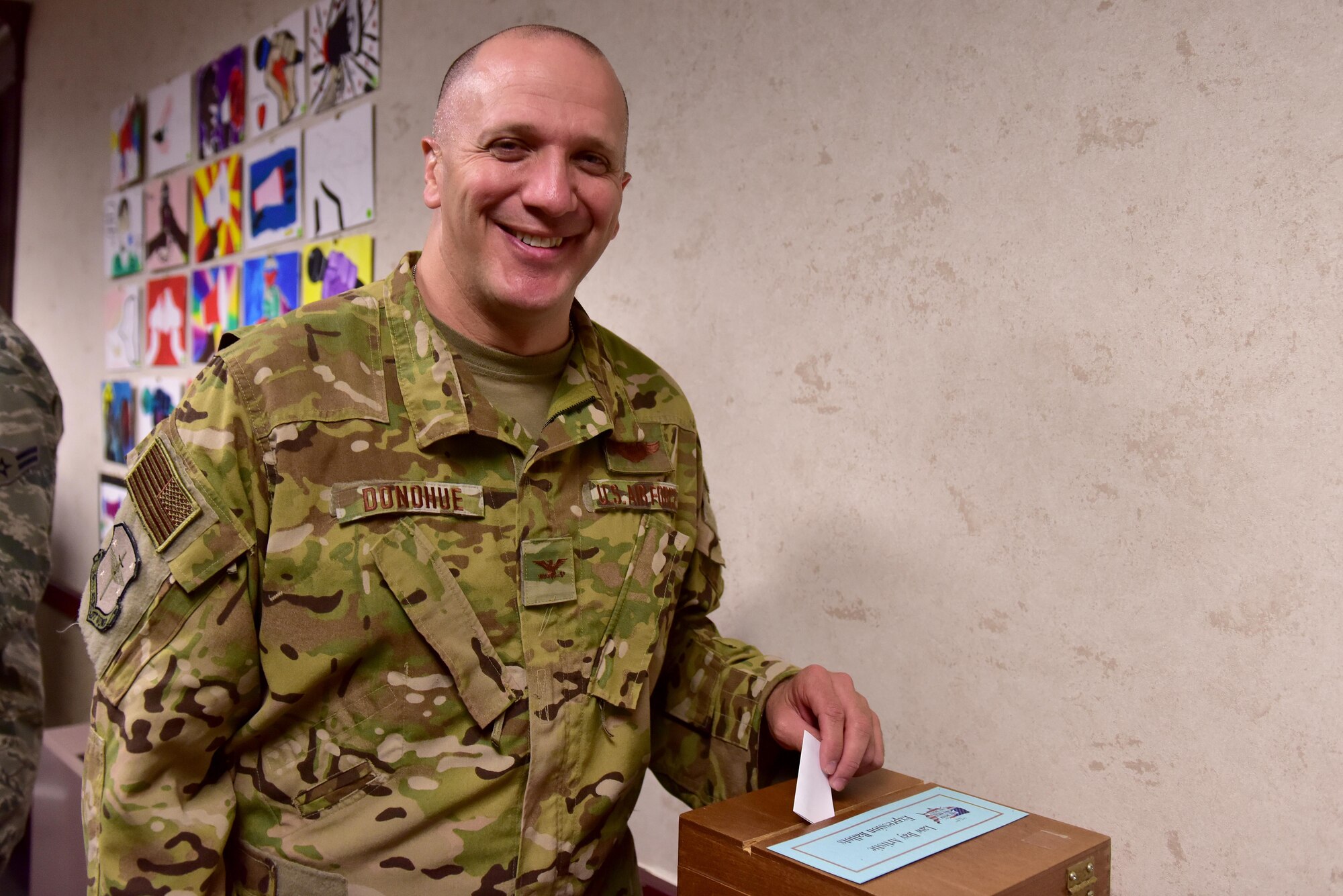 An Airman puts his vote in a ballot box.