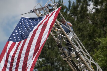 A Port Wentworth firefighter climbs down a ladder after securing the U.S. flag at a memorial ceremony May 2, 2019, in Port Wentworth GA. The event paid homage to the lives of the nine Puerto Rican Air National Guard Airmen who lost their lives when their C-130 Hercules, assigned to the 156th Airlift Wing, crashed May 2, 2018.