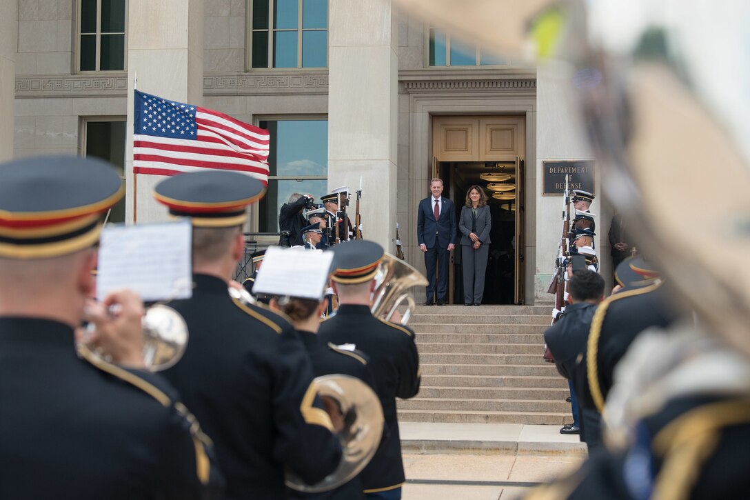 Acting Defense Secretary Patrick M. Shanahan stands at the top of steps with the Colombian Vice President; service members stand on each side.