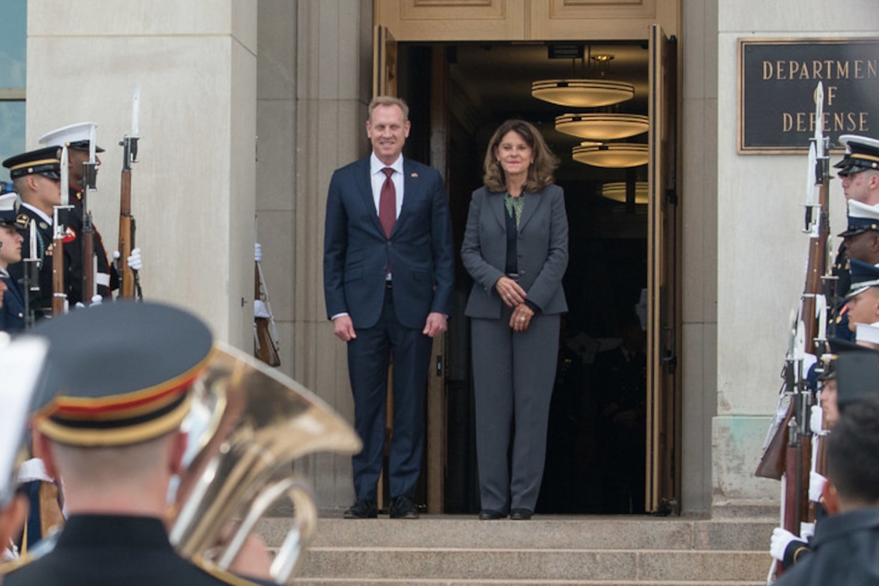 Acting Defense Secretary Patrick M. Shanahan stands at the top of steps with the Colombian Vice President; service members stand on each side.