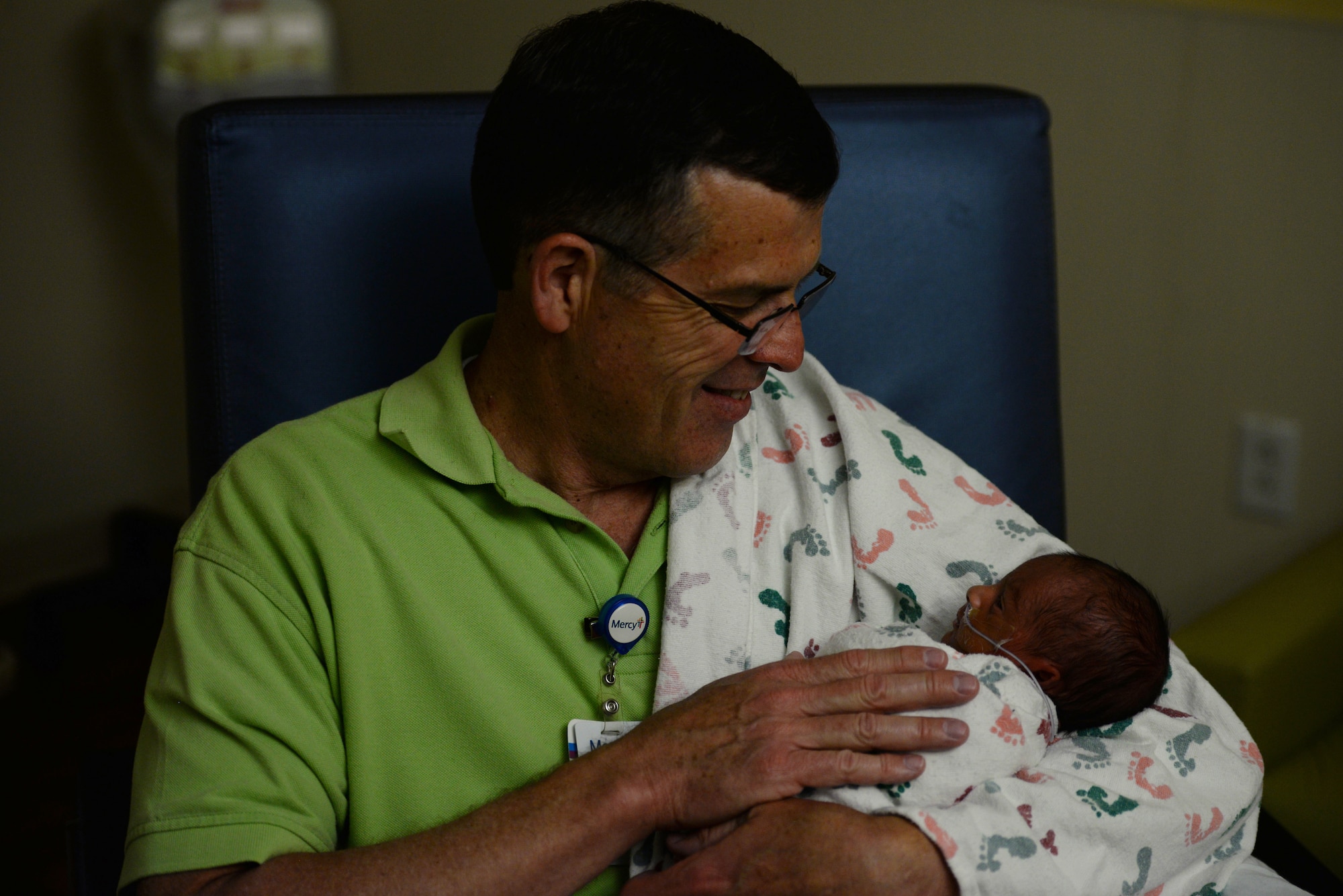 David Young, 60, Air Mobility Command current operations air mobility analyst and retired Air Force pilot, holds the premature grandson of a retired Air Force member while in the Neonatal Intensive Care Unit at Mercy Hospital in St. Louis, April 19, 2019. Young has been a volunteer for the hospital’s “cuddler program” for a year and a half. He has eight children of his own and was interested in the program because his youngest child, now 17 years old, was born eight weeks early. (U.S. Air Force photo by Airman 1st Class Miranda Simpson)