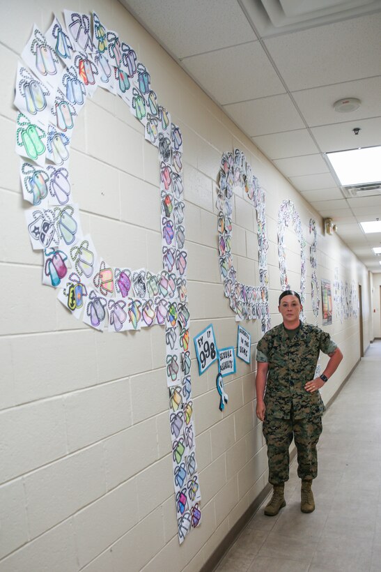 Sgt. Brittany Callaway stands in front of a Sexual Assault Awareness Month display at Marine Wing Support Detachment 273 aboard Marine Corps Air Station Beaufort, May 1. Callaway had the Marines of the detachment show their support of SAAPM by decorating 998 dog tags to bring awareness to the 998 sexual assaults reported in FY17. “We talked about how those numbers have gone up, but because Marines are more aware and are more comfortable reporting it because of the education and the climate of their units,” Callaway said. “This was also a way to start a sometimes uncomfortable conversation.” Callaway is a sexual assault prevention and response advocate with MWSD-273.