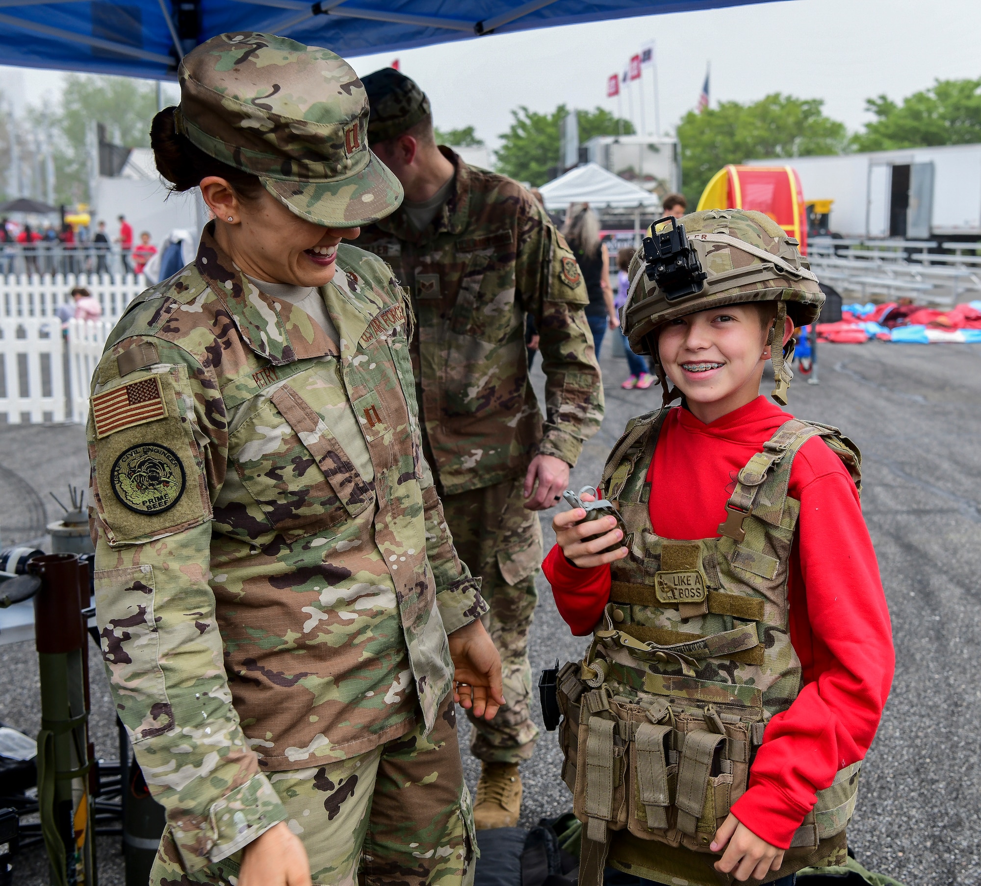 Capt. Michelle Petry, 436th Civil Engineer Squadron Explosive Ordnance Disposal flight commander, helps Reagan Fesel don military gear May 4, 2019, at Dover International Speedway, Dover, Del. The EOD technicians, firefighters, and Security Forces Squadron members set up static displays to provide a hands-on experience to those attending the races.  (U.S. Air Force photo by Senior Airman Christopher Quail)