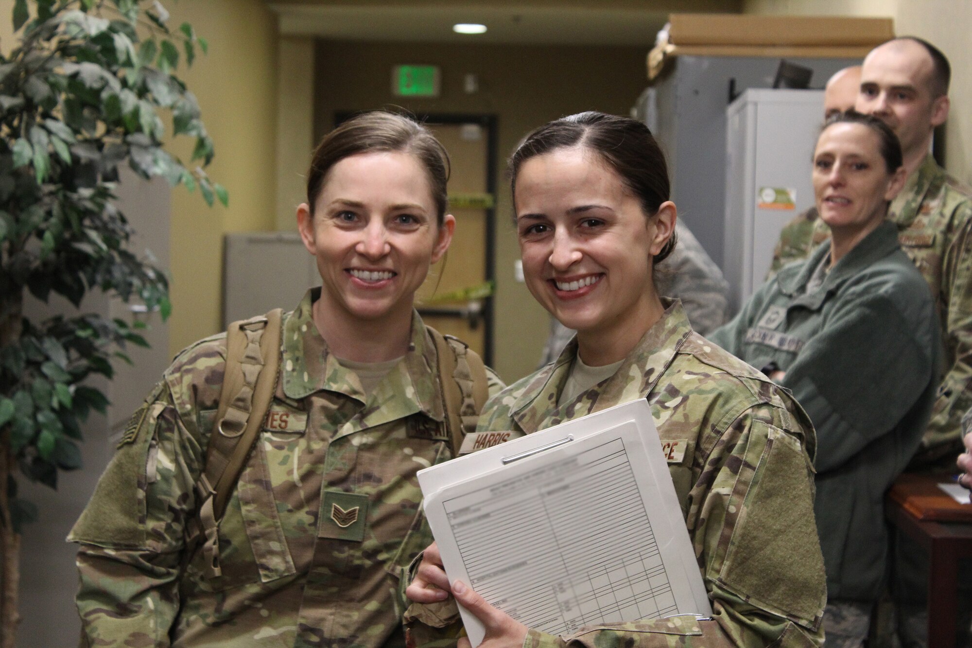 Staff Sgts. Brittany Toennies and Kayla Harris, 718th Intelligence Squadron imagery analysts, are greeted in the Valley of the Eagles by the 755th Intelligence, Surveillance and Reconnaissance Group leadership, 718th IS members and the 497th Intelligence, Surveillance and Reconnaissance Group’s moral dog, Sam, after returning home from their deployment in April. (Courtesy photo)
