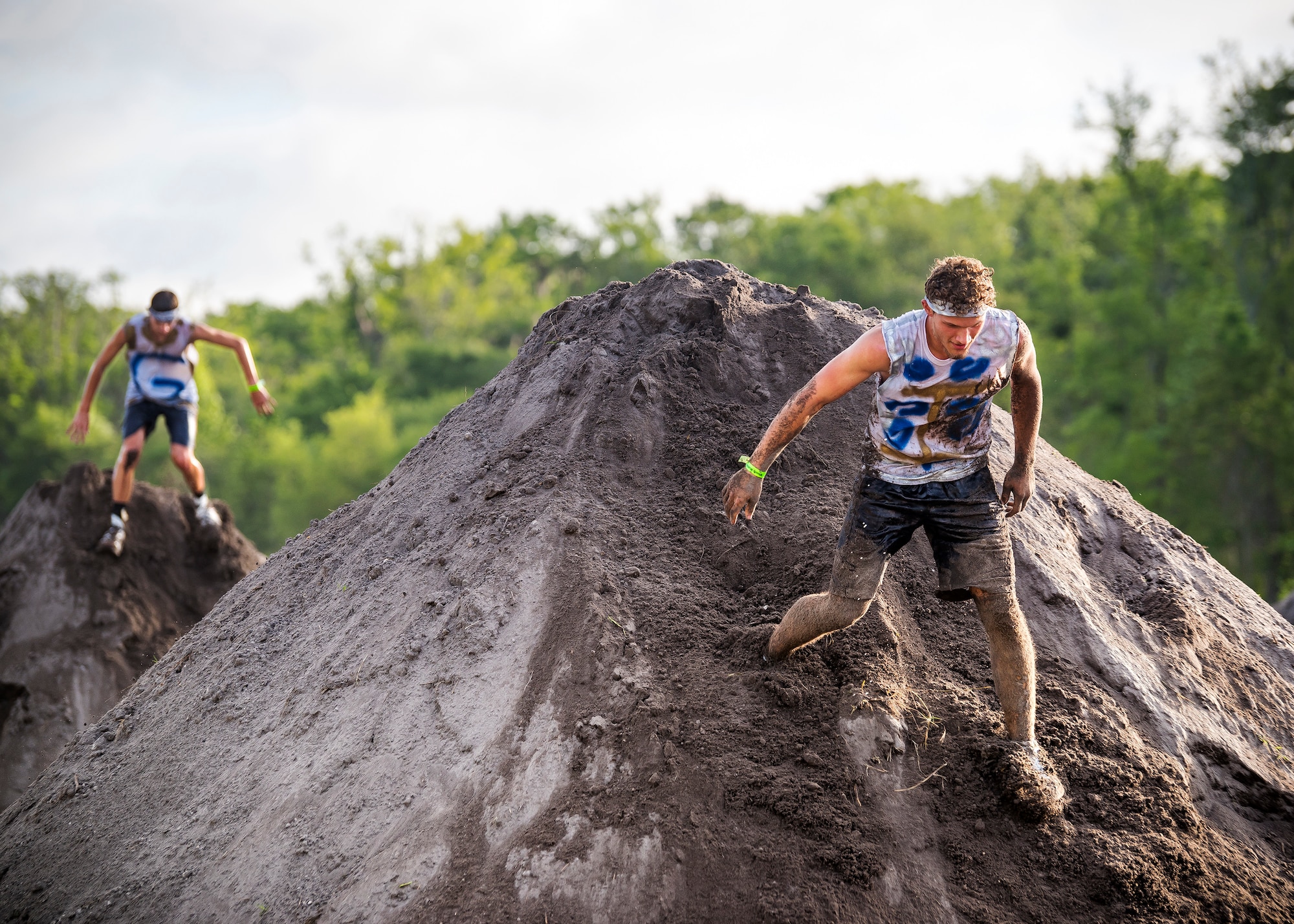 Moody Mud Run participants slide down dirt inclines, May 4, 2019, in Ray City, Ga. The sixth annual Mud Run had approximately 850 participants who had to overcome a series of obstacles on the 4 and 5-mile courses. The 32-obstacle course gave Airmen, families and the local community an opportunity to build camaraderie and teamwork skills. (U.S. Air Force photo by Airman 1st Class Eugene Oliver)