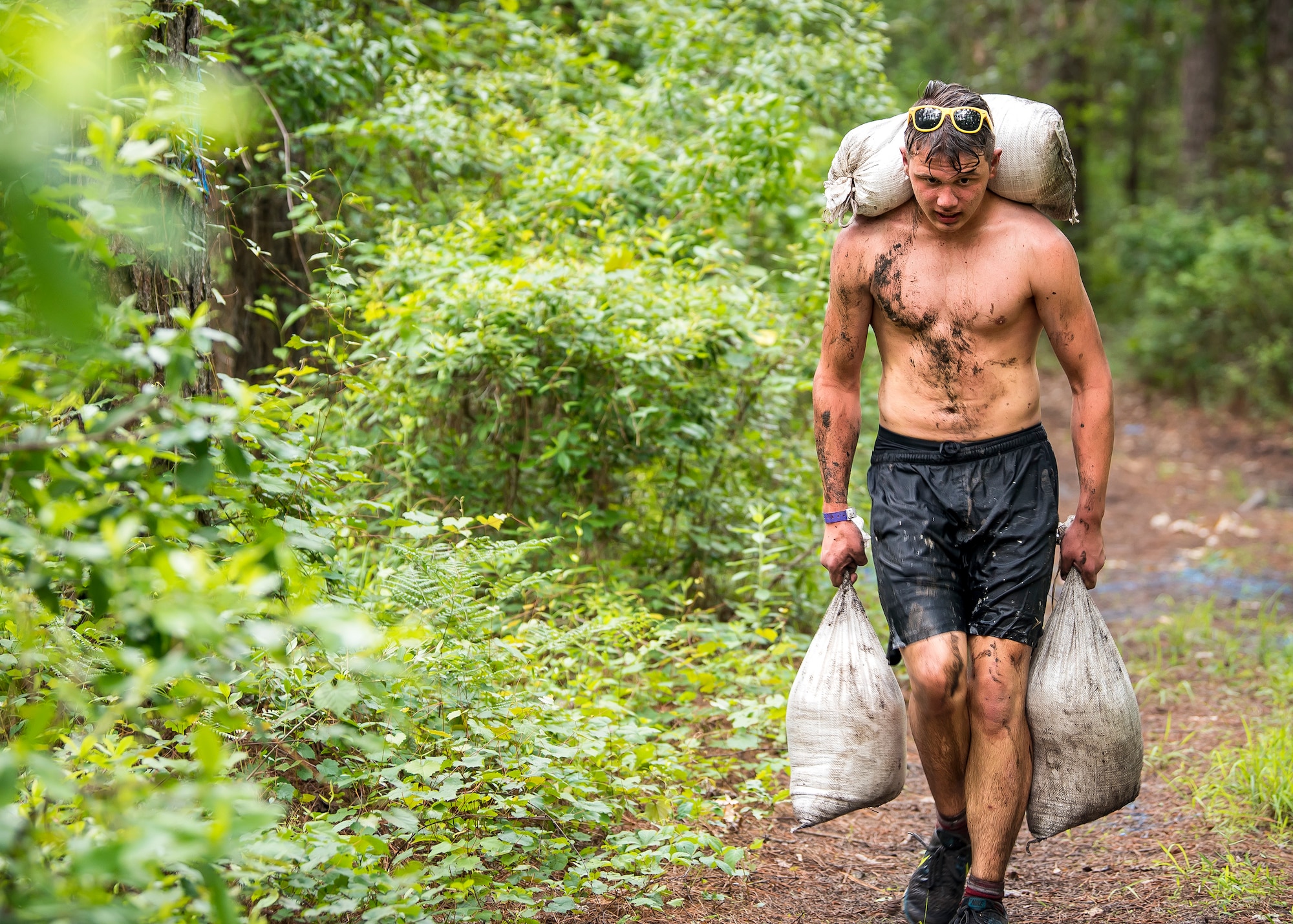 A Moody Mud Run participant carries sandbags, May 4, 2019, in Ray City, Ga. The sixth annual Mud Run had approximately 850 participants who had to overcome a series of obstacles on the 4 and 5-mile courses. The 32-obstacle course gave Airmen, families and the local community an opportunity to build camaraderie and teamwork skills. (U.S. Air Force photo by Airman 1st Class Eugene Oliver)