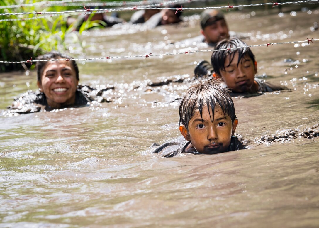 Moody Mud Run participants swim under a barbwire obstacle, May 4, 2019, in Ray City, Ga. The sixth annual Mud Run had approximately 850 participants who had to overcome a series of obstacles on the 4 and 5-mile courses. The 32-obstacle course gave Airmen, families and the local community an opportunity to build camaraderie and teamwork skills. (U.S. Air Force photo by Airman 1st Class Eugene Oliver)