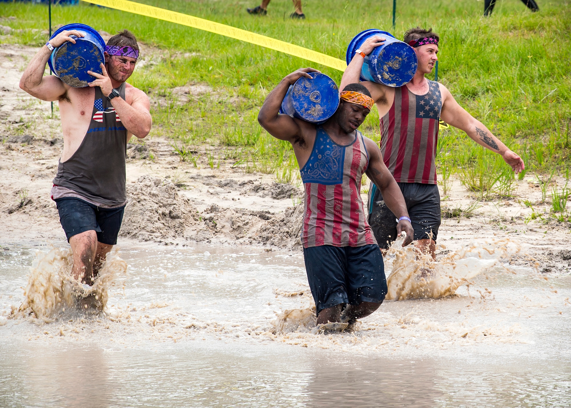 Moody Mud Run participants carry jugs, May 4, 2019, in Ray Ciy, Ga. The sixth annual mud run had approxamately 850 particpants who had to overcome a series of obstacles on the 4 and 5-mile courses. The 32-obstacle course gave Airmen, families and the local community an opportunity to build camaraderie and teamwork skills. (U.S. Air Force photo by Airman 1st Class Eugene Oliver)