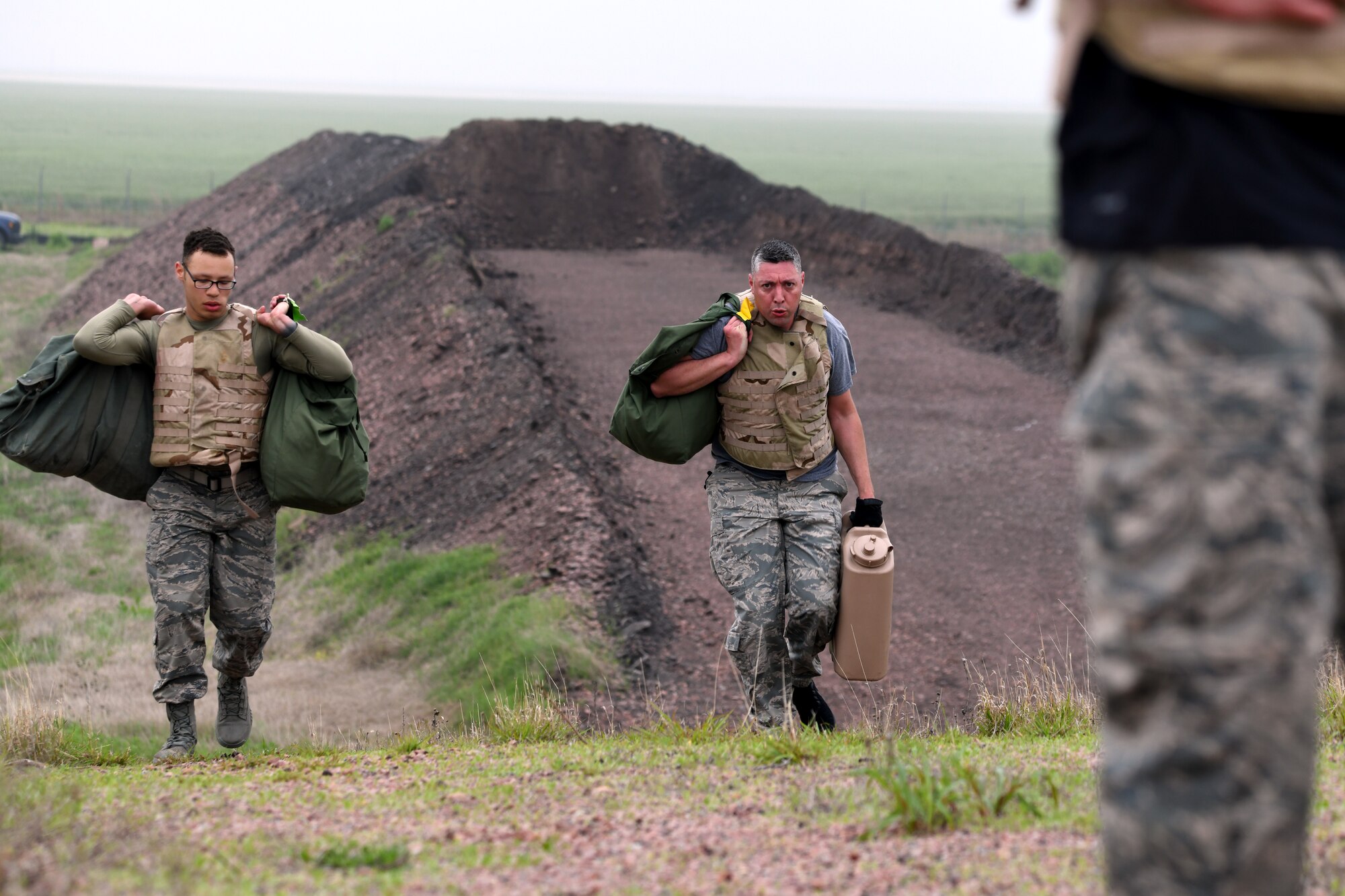 U.S. Air Force Airman First Class Donovan Cash (left) and Technical Sergeant Brian Toth, 97th Logistics Readiness Squadron Fuels Management Flight, carry mobility bags and jerry cans over obstacles during the LRS Warrior Challenge May 6, 2019, at Altus Air Force Base, Okla. While participating in the event, they completed challenges measuring both their physical strength and military knowledge. (U.S. Air Force photo by Technical Sergeant Robert Sizelove)