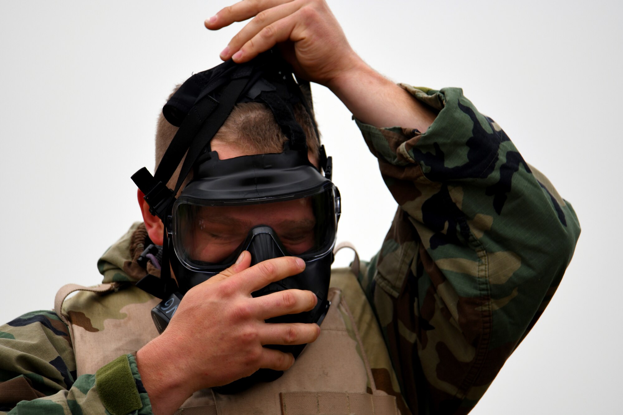 U.S. Air Force Staff Sargent Jared Hoover, 97th Logistics Readiness Squadron, Ground Transportation Operator, puts on an M50 gas mask during the LRS Warrior Challenge May 6, 2019, at Altus Air Force Base, Okla. While participating in the event, they completed challenges measuring both their physical strength and military knowledge such as finding unexploded ordinance and detecting simulated chemical, biological, radiological, and nuclear contamination. (U.S. Air Force photo by Technical Sergeant Robert Sizelove)