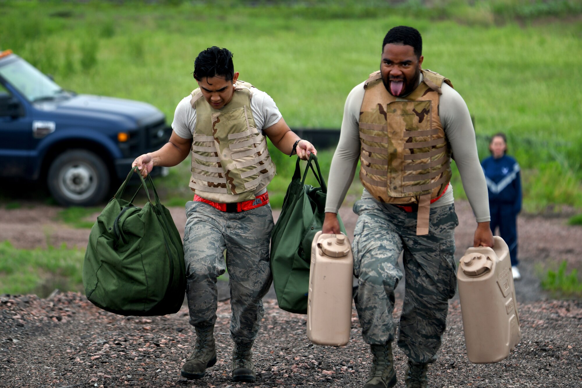 U.S. Air Force Airman First Class Jericho Masangkay (left) and Airman Devin Johnson, 97th Logistics Readiness Squadron Aerial Operations Apprentices, carry jerry cans and mobility bags up a hill during the obstacle course portion of the LRS Warrior Challenge May 6, 2019, at Altus Air Force Base, Okla. The challenge consisted of teams of four who race to complete a 2.5 mile course. (U.S. Air Force photo by Technical Sergeant Robert Sizelove)