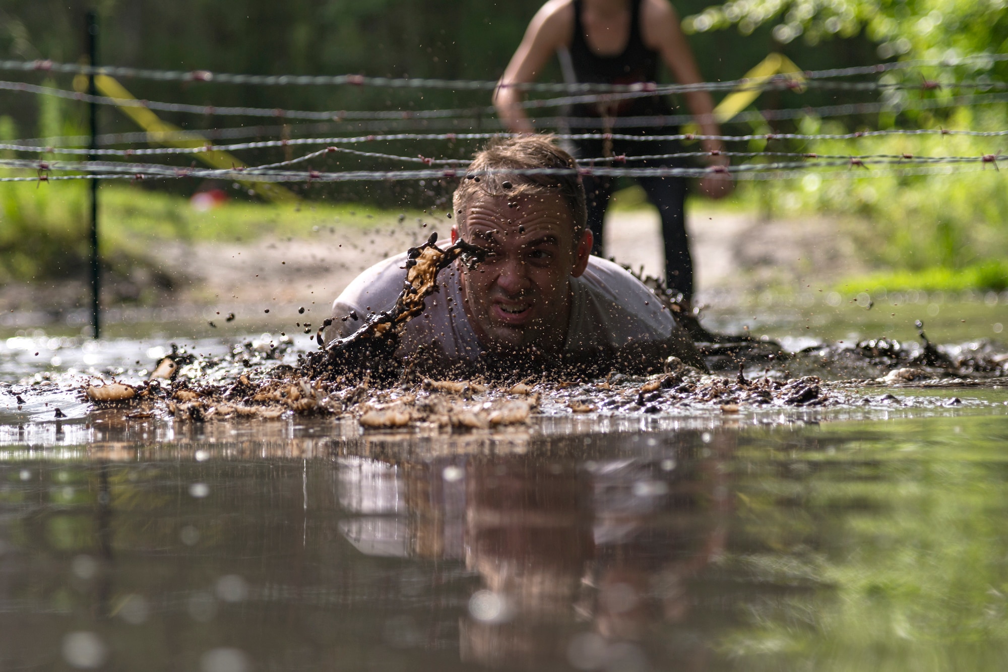 A participant crawls under barbed wire during the Moody Mud Run, May 4, 2019, at Possum Creek Off-Road Park in Ray City, Ga. The sixth annual Moody Mud Run had approximately 850 participants who had to overcome a series of obstacles on the 4 and 5-mile courses. The 32-obstacle course gave Airmen, families and the local community an opportunity to build camaraderie and teamwork skills. (U.S. Air Force Photo by Airman 1st Class Taryn Butler)